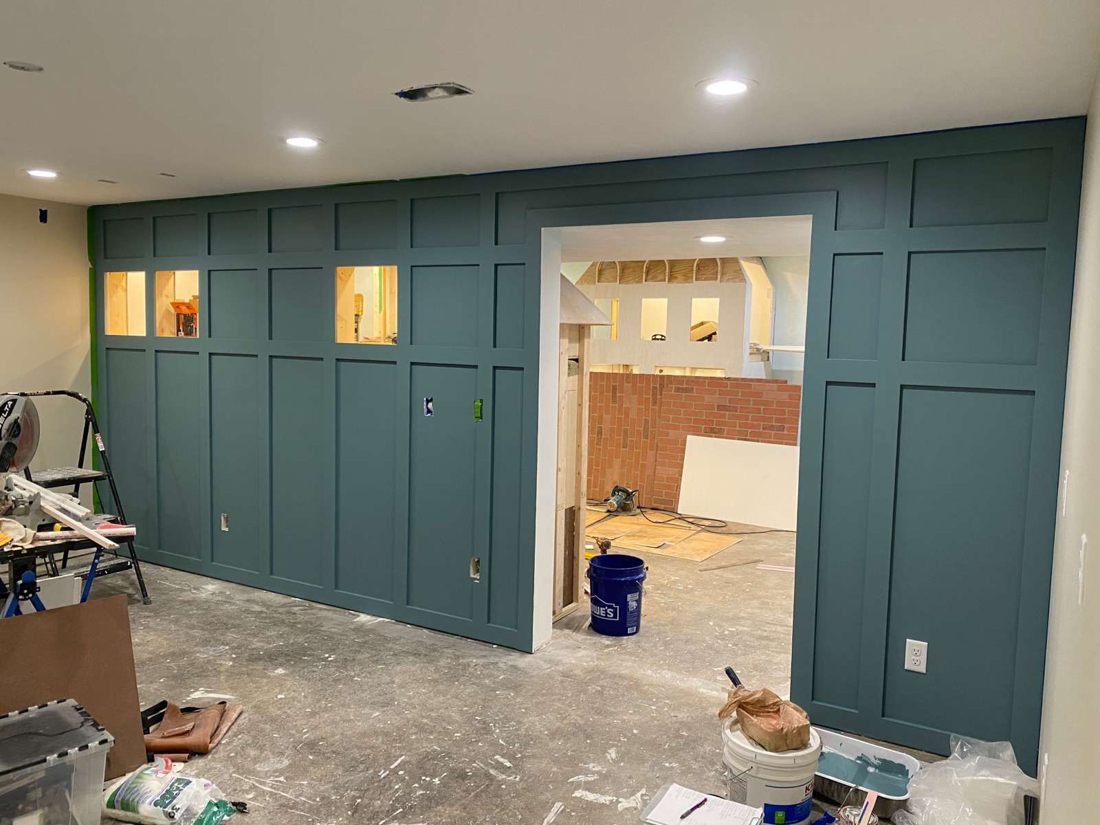 Board-and-batten accent wall mid-construction with miter saw and tools