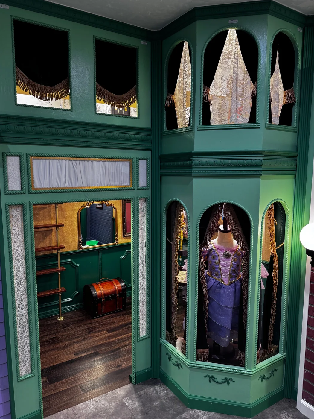 C&G Clothier's playhouse — an emerald dress shop with a corner display bay and a fitting room