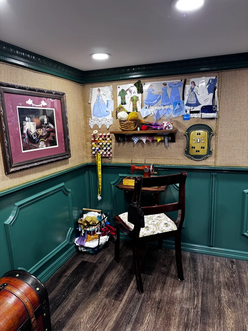 Inside the Clothier's — emerald walls dressed with framed fashion prints and a styling table