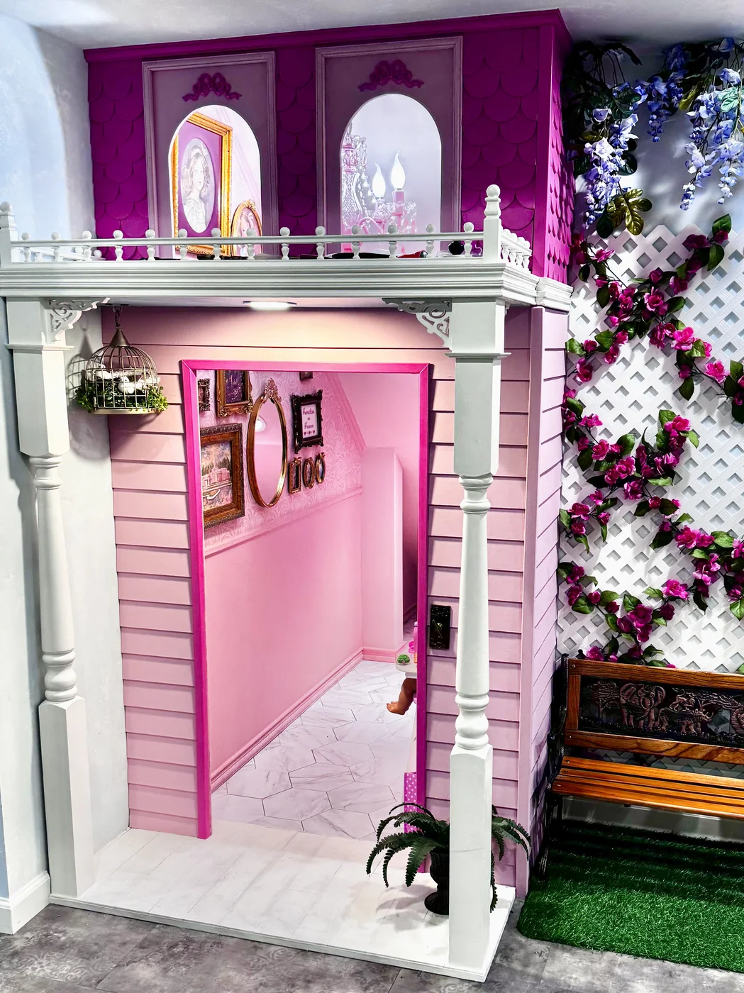 Rose Cottage playhouse — a pink Victorian with a balcony, arched windows, and a rose-covered trellis